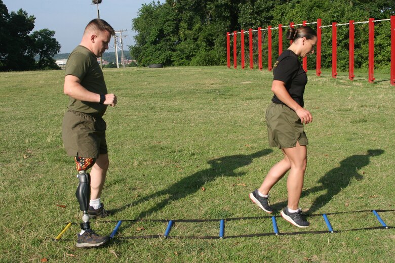 Master Sgt. Berle Sigman, a student in the Faculty Advisors Course (FAC) at the Quantico Staff Non-Commissioned Officer (SNCO) Academy, completes a High Intensity Tactical Training (HITT) physical training session aboard Marine Corps Base Quantico June 27 with Master Gunnery Sgt. Amber Hecht, a lead instructor in the FAC. Sigman, whose original Military Occupational Specialty was 0369 Infantryman, will teach warfighting classes at the SNCO Academy after he graduates from the course on June 29. He was injured in Ramadi, Iraq in 2004, leading to the loss of his leg.