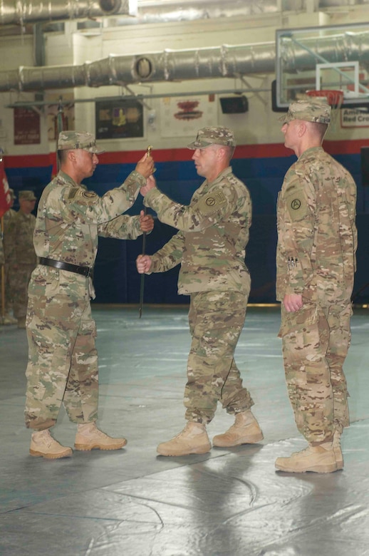 Command Sgt. Maj. Eric J. Alfieri, former Area Support Group Kuwait command sergeant major, receives the noncommissioned officers sword from Sgt. 1st Class George
Ruiz, ceremony commander of troops, during an ASG-KU relinquishment of responsibility ceremony at Camp Arifjan, July 2. Alfieri passed the noncommissioned officer sword to Col. Jeff R. Stewart, Area Support Group Kuwait commander, signifying the relinquishment of responsibility and authority from the outgoing to the incoming command sergeant major.