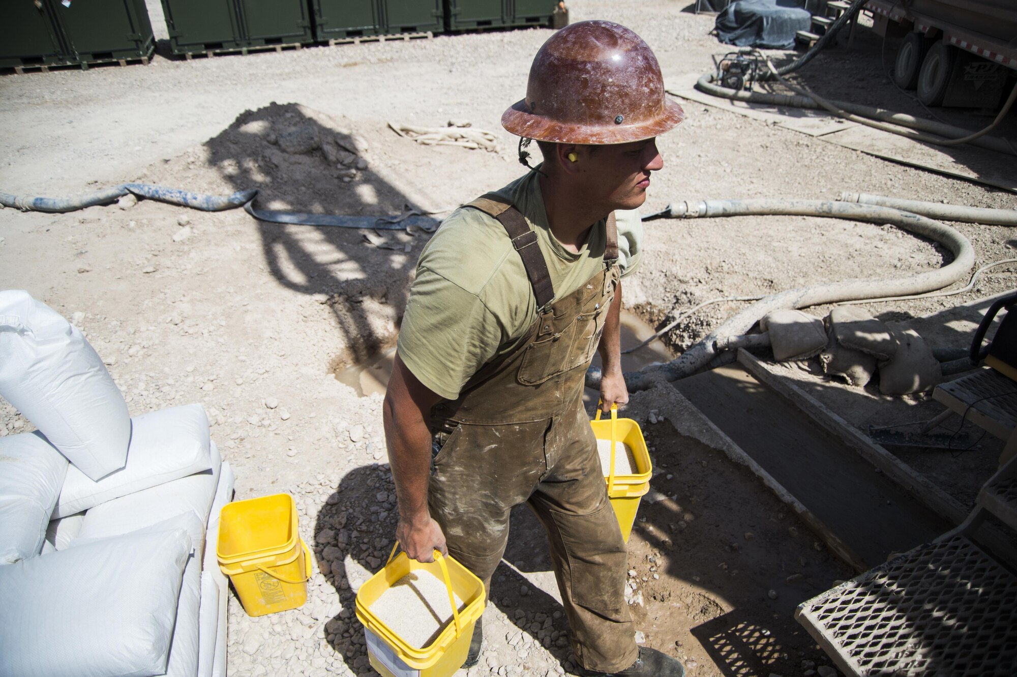 Staff Sgt. Donald Fisher, a well drilling technician assigned to the 557th Expeditionary Red Horse Squadron, carries buckets of sand to pour down the well site at Al Taqaddum Air Base, Iraq, June 2, 2016. The 557th ERHS well drilling team are obtaining an organic water source for Al Taqaddum. Red Horse is helping to improve Iraq's infrastructure in support of the Government of Iraq.
(U.S. Air Force photo/Staff Sgt. Larry E. Reid Jr., Released)