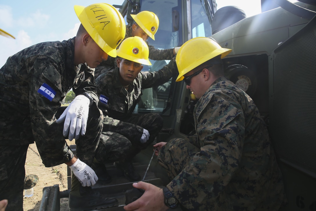 Corporal Kaleb R. Hougland, senior heavy equipment mechanic, conducts a period of instruction on the maintenance of a Caterpillar D6K Bulldozer at Puerto Castilla, Honduras, June 24, 2016. The Marines worked side-by-side on different construction and restoration projects, and shared knowledge and experience on techniques including maintenance and operation of heavy equipment. (U.S Marine Corps Photo by Cpl. Ian Ferro/Released)
