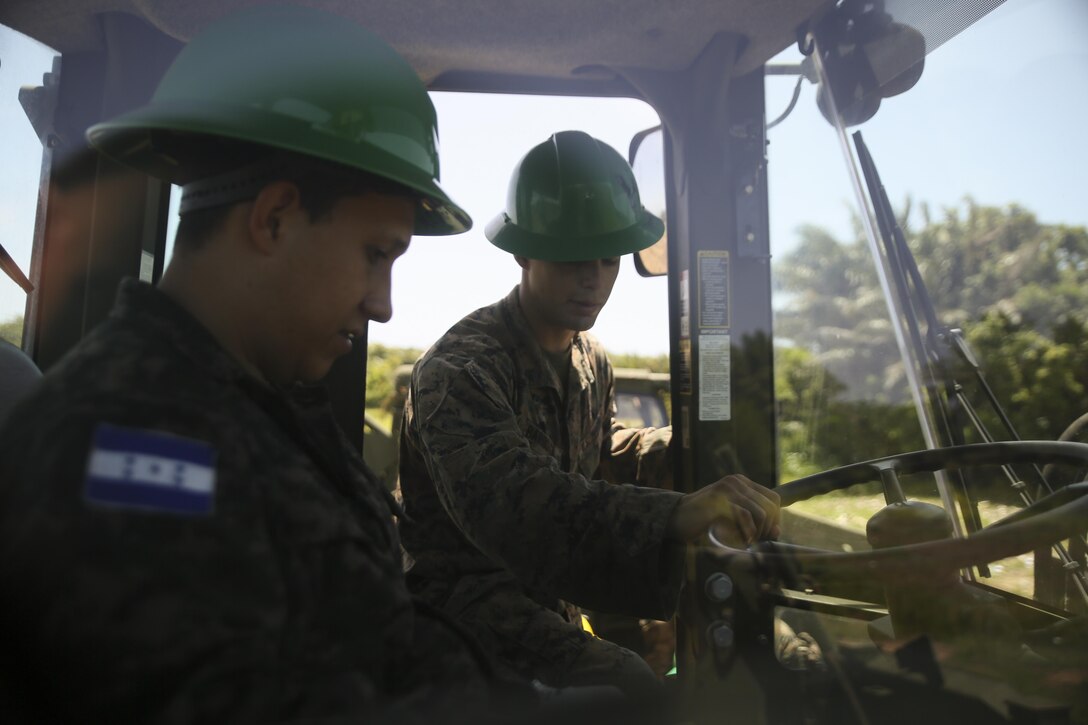 Cpl. Ivan A.  Barbosa, a heavy equipment operator with Special Purpose Marine Air-Ground Task Force - Southern Command, conducts a period of instruction on basic operation and capabilities of a 624KR TRAM during a construction project between Honduran service members and U.S. Marines at Puerto Castilla, Honduras, June 24, 2016. The Marines worked side by side Honduran engineers on different construction and restoration projects, and shared knowledge and experience on techniques including maintenance and operation of heavy equipment. (U.S Marine Corps photo by Cpl. Ian Ferro/Released)