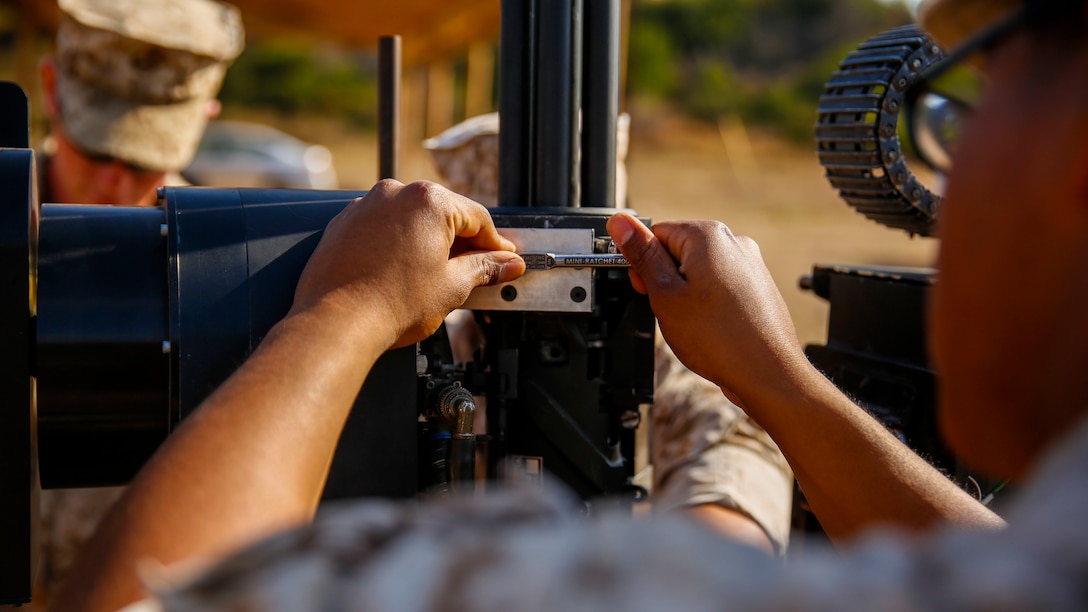 Lance Cpl.  Jorge Sainz, a rifleman with Kilo Company, 3rd Battalion, 5th Regiment, attaches the M134 Minigun to the Robotic Vehicle Modular system aboard Camp Pendleton, June 23, 2016. The Marines were learning how to operate the system which is going to be tested during Rim of the Pacific 2016 with partner nations. The RVM is designed to assist an infantry platoon by providing more fire power, bearing equipment loads and designating targets for air assaults. The Marine Corps Warfighting Laboratory is conducting a Marine Air-Ground Task Force Integrated Experiment to explore new gear and access its capabilities for potential future use. (U.S. Marine Corps photo by Lance Cpl. Frank Cordoba/Released)
