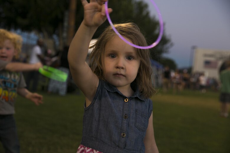 Janelle Wright, 3, daughter of Joy and Jeff Wright, of Twentynine Palms, plays with her glow stick during the Twentynine Palms Independence Day Celebration at Luckie Park in Twentynine Palms, Calif., July 4, 2016. (Official Marine Corps photo by Lance Cpl. Dave Flores/Released)