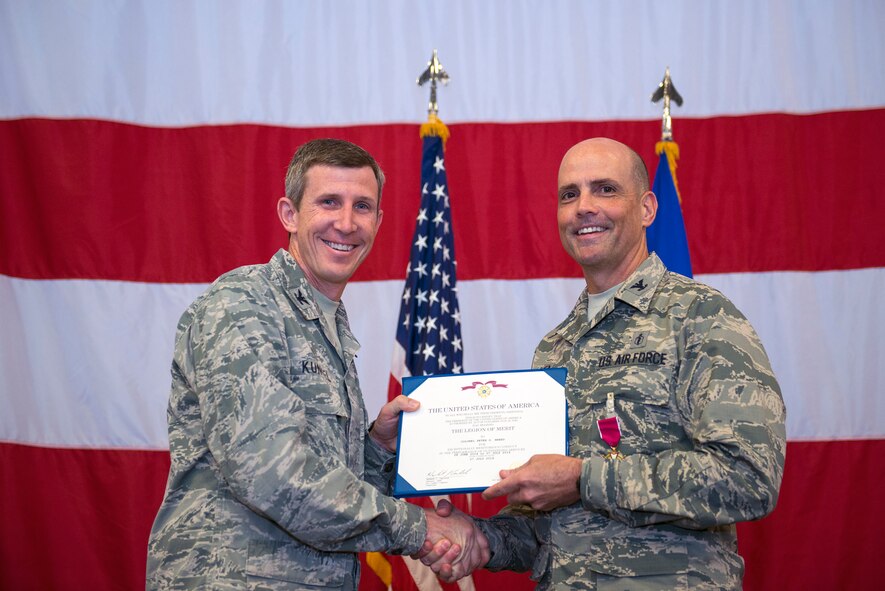 U.S. Air Force Col. Thomas Kunkel, 23d Wing commander, presents the Legion of Merit award to Col. Peter Breed, 23d Medical Group outgoing commander, during a change of command ceremony, July 8, 2016, at Moody Air Force Base, Ga. During his command, Breed led three squadrons comprised of approximately 300 medics in support of Team Moody’s nearly 11,000 active-duty, dependent and retiree beneficiaries. (U.S. Air Force photo by Airman 1st Class Greg Nash/Released)