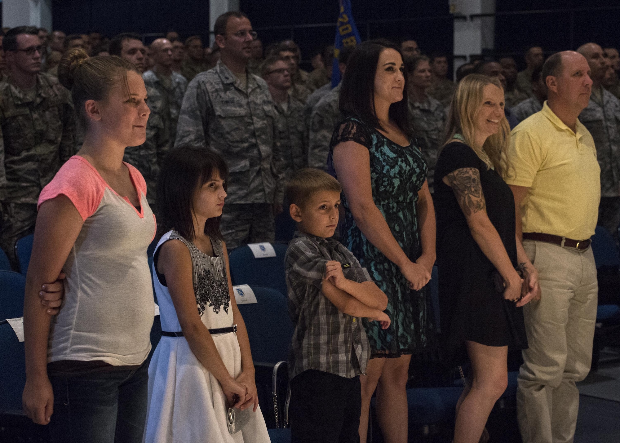 Family and friends of U.S. Air Force Master Sgt. Aaron Frederick, 93d Air Ground Operations Wing command chief executive assistant and Staff Sgt. Bradley Mock 824 Base Defense Squadron superintendent of supply, rise for the entrance of the official party, July 8, 2016, at Moody Air Force Base, Ga. The 820th Base Defense Group awarded Frederick and Mock each a Bronze Star with Valor, Air Force Combat Action Medal and Purple Heart for their actions during an attack Dec. 21, 2015, in Southwest Asia. (U.S. Air Force photo by Airman 1st Class Janiqua P. Robinson/Released)