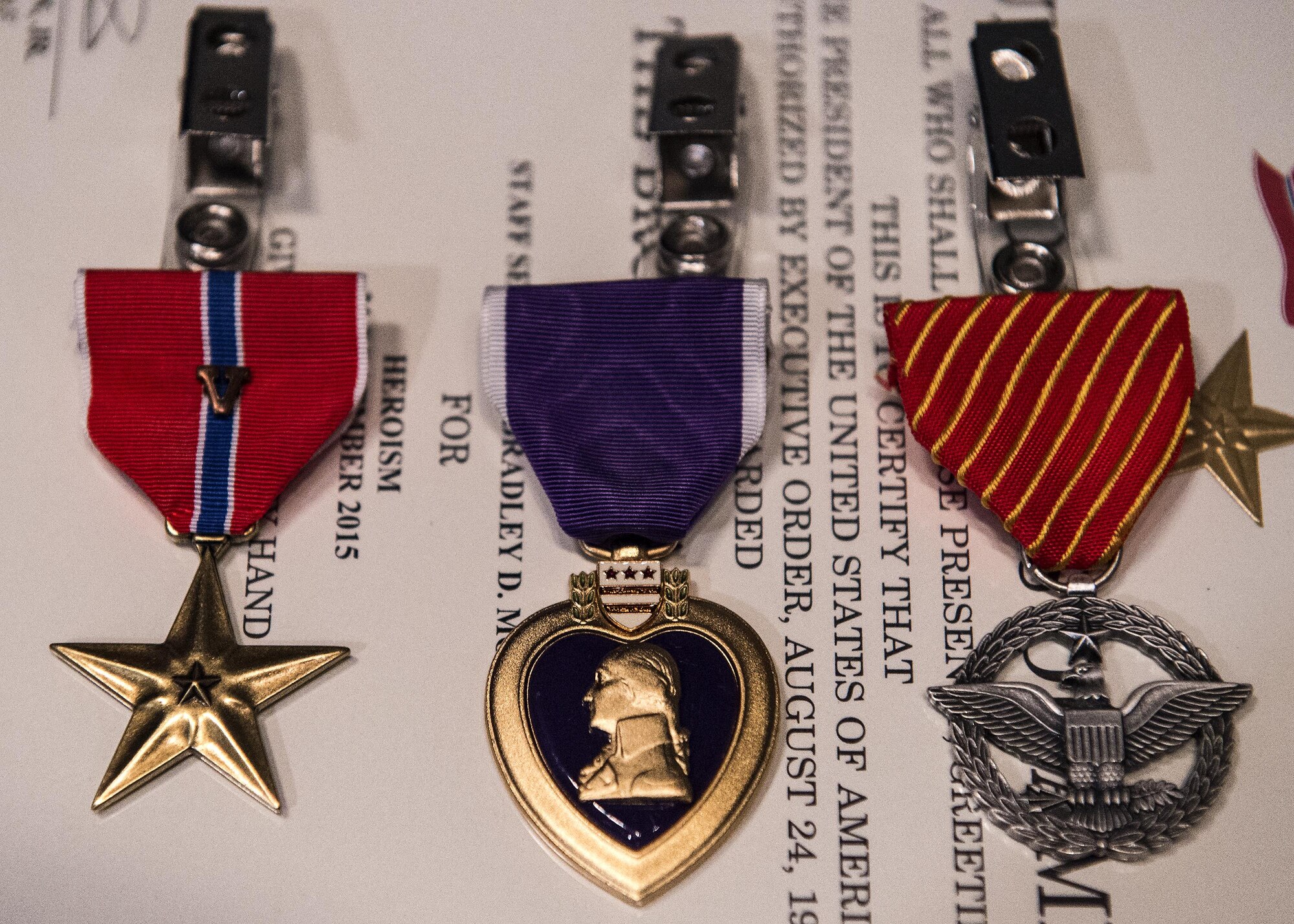 Medals sit on display during a medallion ceremony, July 8, 2016, at Moody Air Force Base, Ga. The 820th Base Defense Group presented a Bronze Star with Valor, Air Force Combat Action Medal and Purple Heart to both U.S. Air Force Master Sgt. Aaron Frederick, 93d Air Ground Operations Wing command chief executive assistant and Staff Sgt. Bradley Mock 824 Base Defense Squadron superintendent of supply, for their actions during an attack Dec. 21, 2015, in Southwest Asia. (U.S. Air Force photo by Airman 1st Class Janiqua P. Robinson/Released)