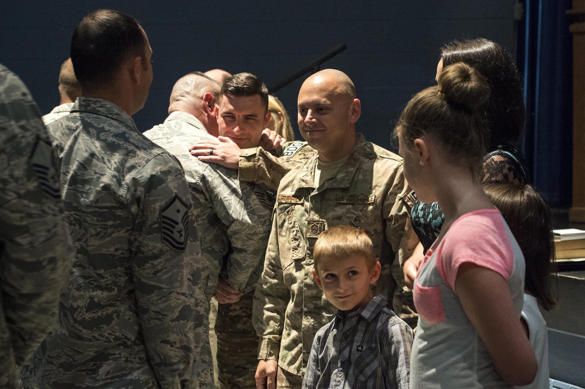 Airmen from the 820th Base Defense Group embrace Master Sgt. Aaron Frederick, 93d Air Ground Operations Wing command chief executive assistant, and Staff Sgt. Bradley Mock 824 Base Defense Squadron superintendent of supply, for their heroic actions after a medallion ceremony, July 8, 2016, at Moody Air Force Base, Ga. Both Frederick and Mock earned an Air Force Combat Action Medal, which is awarded to Airmen who have been under direct and hostile fire while operating outside the defended perimeter or physically engaging hostile forces with direct and lethal fire. (U.S. Air Force photo by Airman 1st Class Janiqua P. Robinson/Released)