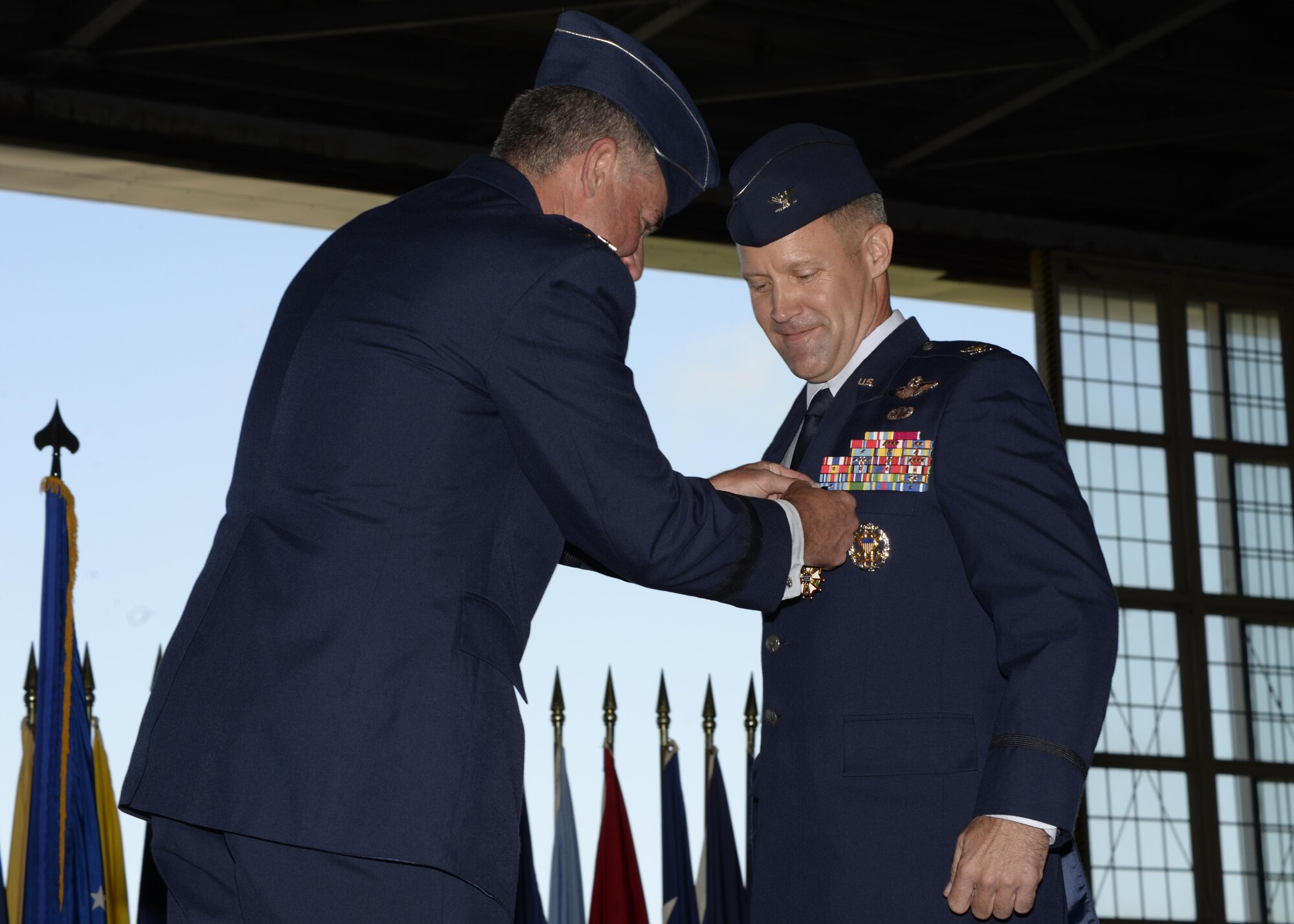 Lt. Gen. Samuel Cox, commander of the 18th Air Force, pins the Legion of Merit medal on Col. Daniel Tulley, outgoing commander of the 6th Air Mobility Wing (AMW), during the wing change of command ceremony at MacDill Air Force Base, Fla., July 8, 2016. During the ceremony, Tulley reliquished command of the 6th AMW to Col. April Vogel. (U.S. Air Force photo by Tech. Sgt. Krystie Martinez)