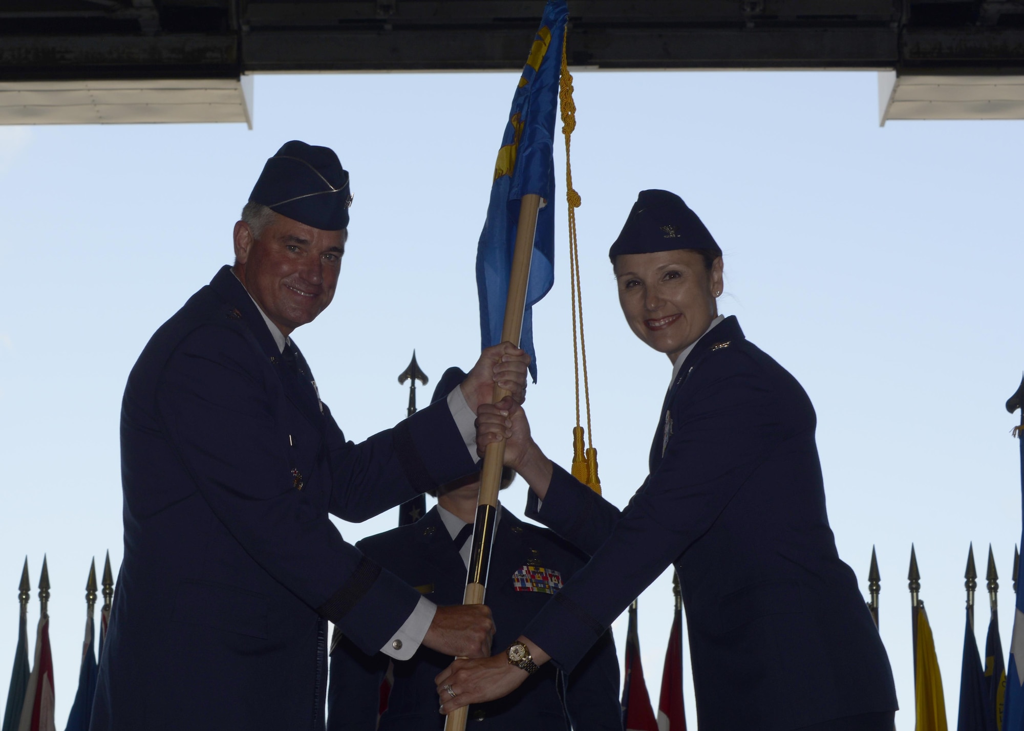 Lt. Gen. Samuel Cox, commander of the 18th Air Force, passes the 6th Air Mobility Wing guidon to the incoming commander, Col. April Vogel, during the wing change of command ceremony at MacDill Air Force Base, Fla., July 8, 2016. During Vogel’s previous assignment she was the vice commander of the 175th Wing, Warfield Air National Guard Base, Md. (U.S. Air Force photo by Tech. Sgt. Krystie Martinez)