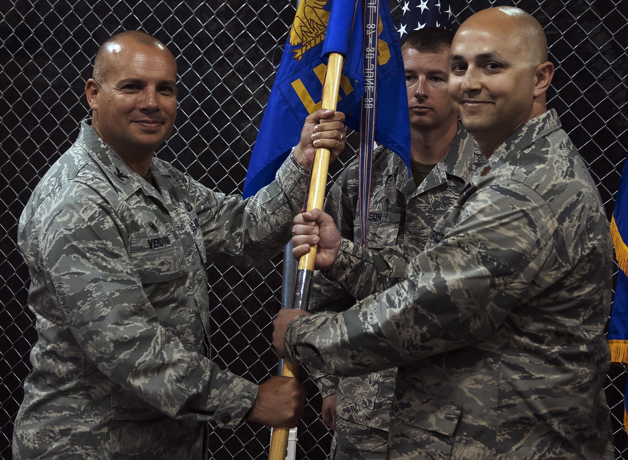 Col. Frank Verdugo, 90th Mission Support Group commander, passes the 90th Logistics Readiness Squadron guidon to the squadron’s new commander, Maj. Marc Hernandez, during a change-of-command ceremony July 8, 2016, on F.E. Warren Air Force Base, Wyo. The ceremony signified the transition of command from Lt. Col. Ross Sutherland to Hernandez. (U.S. Air Force photo by Senior Airman Brandon Valle)