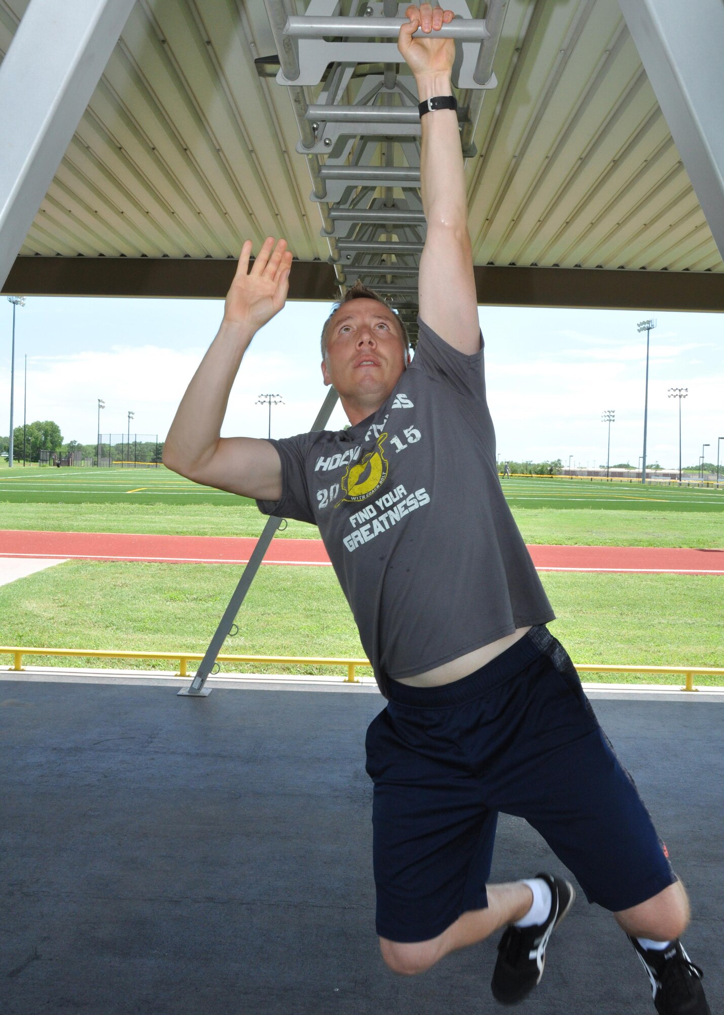 Maj. Brian Doom, 18th Air Refueling Squadron assistant director of operations, climbs along a set of monkey bars July 8, 2016, McConnell Air Force Base, Kansas. Doom used on-base facilities available to McConnell Citizen Airmen to increase his fitness and agility levels to perform in a national fitness competition. (U.S. Air Force photo by Senior Airman Preston Webb)