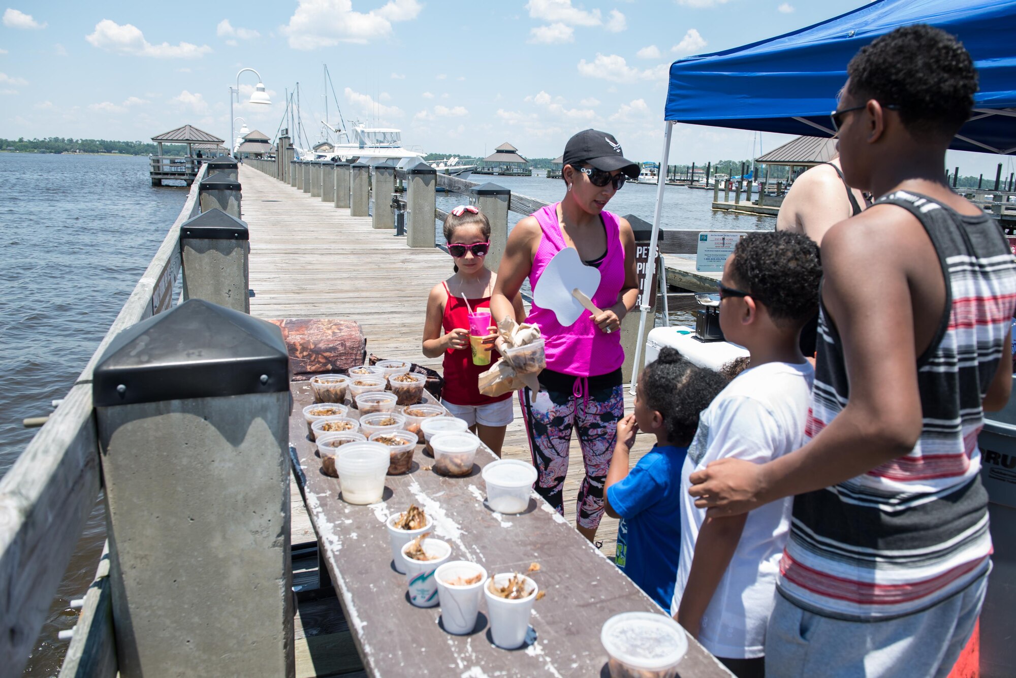 Families gather fishing supplies for the kids’ fishing rodeo during the Celebration of Our Nation event at Marina Park July 2, 2016, on Keesler Air Force Base, Miss. The event also included a golf scramble, mullet toss, fireworks display and music performances. (U.S. Air Force photo by Marie Floyd/Released)