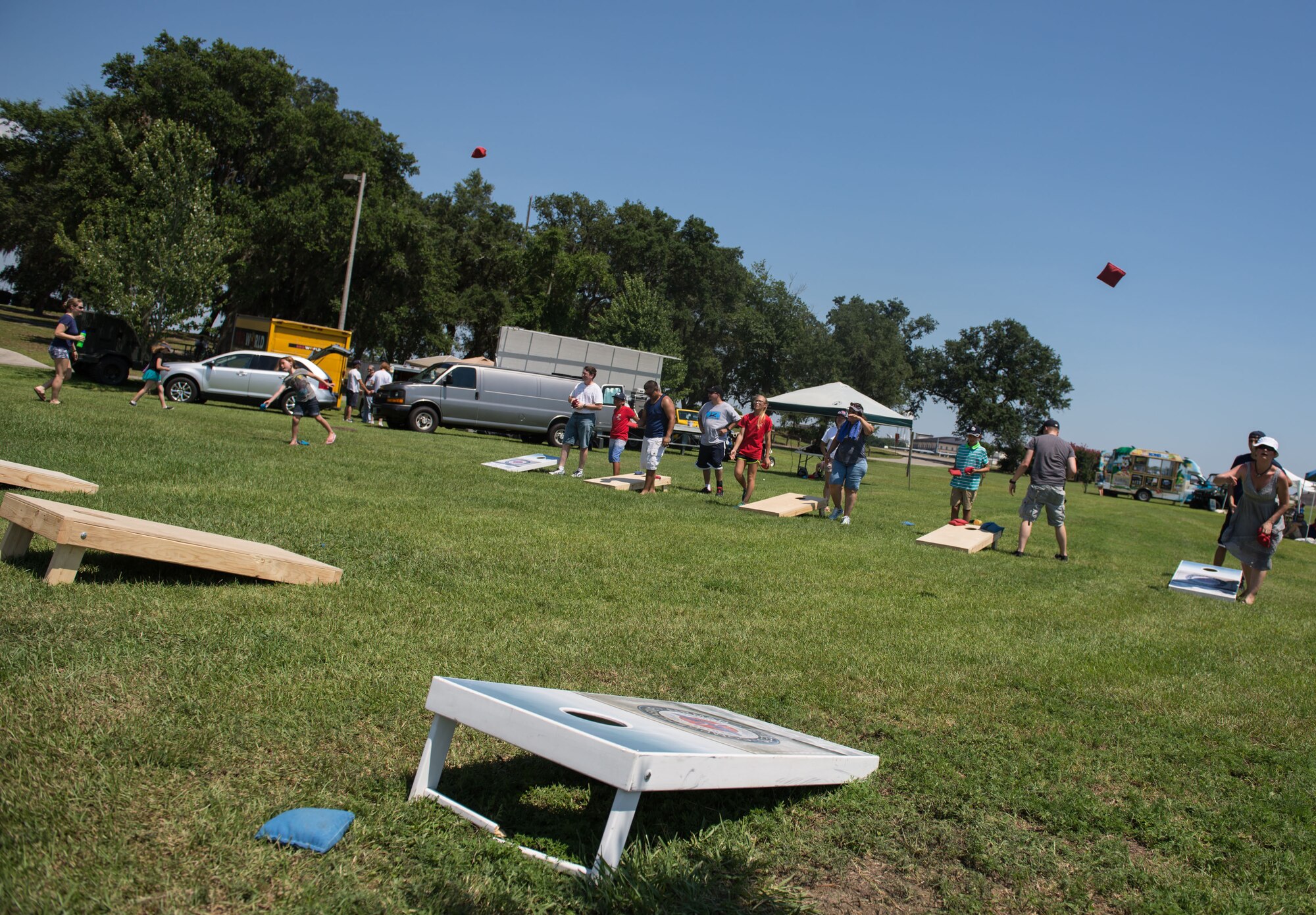 Keesler families participate in a cornhole tournament during the Celebration of Our Nation event at Marina Park July 2, 2016, on Keesler Air Force Base, Miss. The event also included a golf scramble, mullet toss, and fireworks display. (U.S. Air Force photo by Marie Floyd/Released)