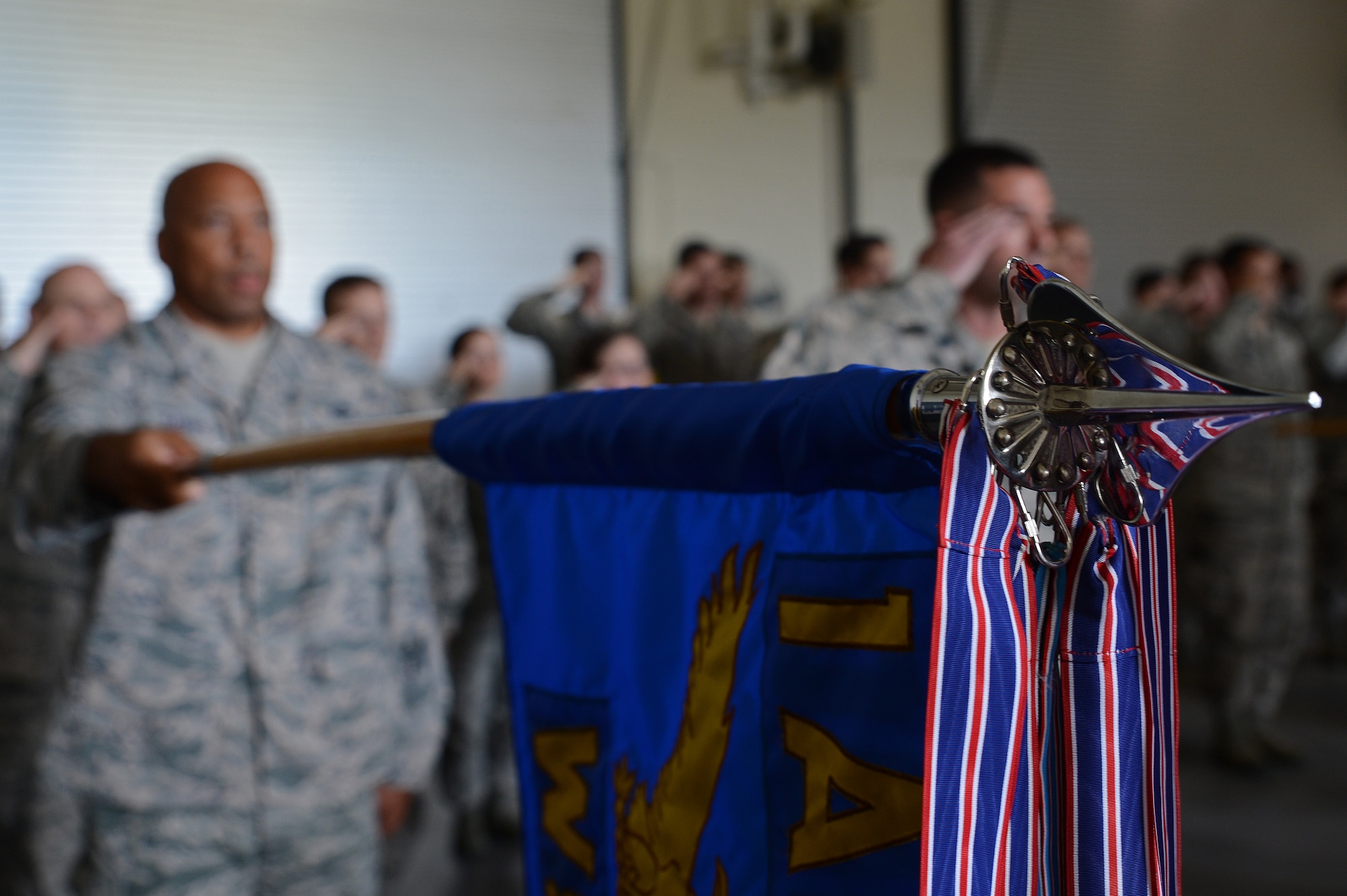 Senior Master Sgt. Malik Barnes, 1st weather Squadron superintendent, presents the 1st WS guidon as the national anthem is played during a change of command ceremony July 7, 2016 at Joint base Lewis-McChord, Wash. The Guidon bears the units colors and is a time honored military tradition of heritage in the Air Force. (U.S. Air Force photo/Senior Airman Jacob Jimenez)   