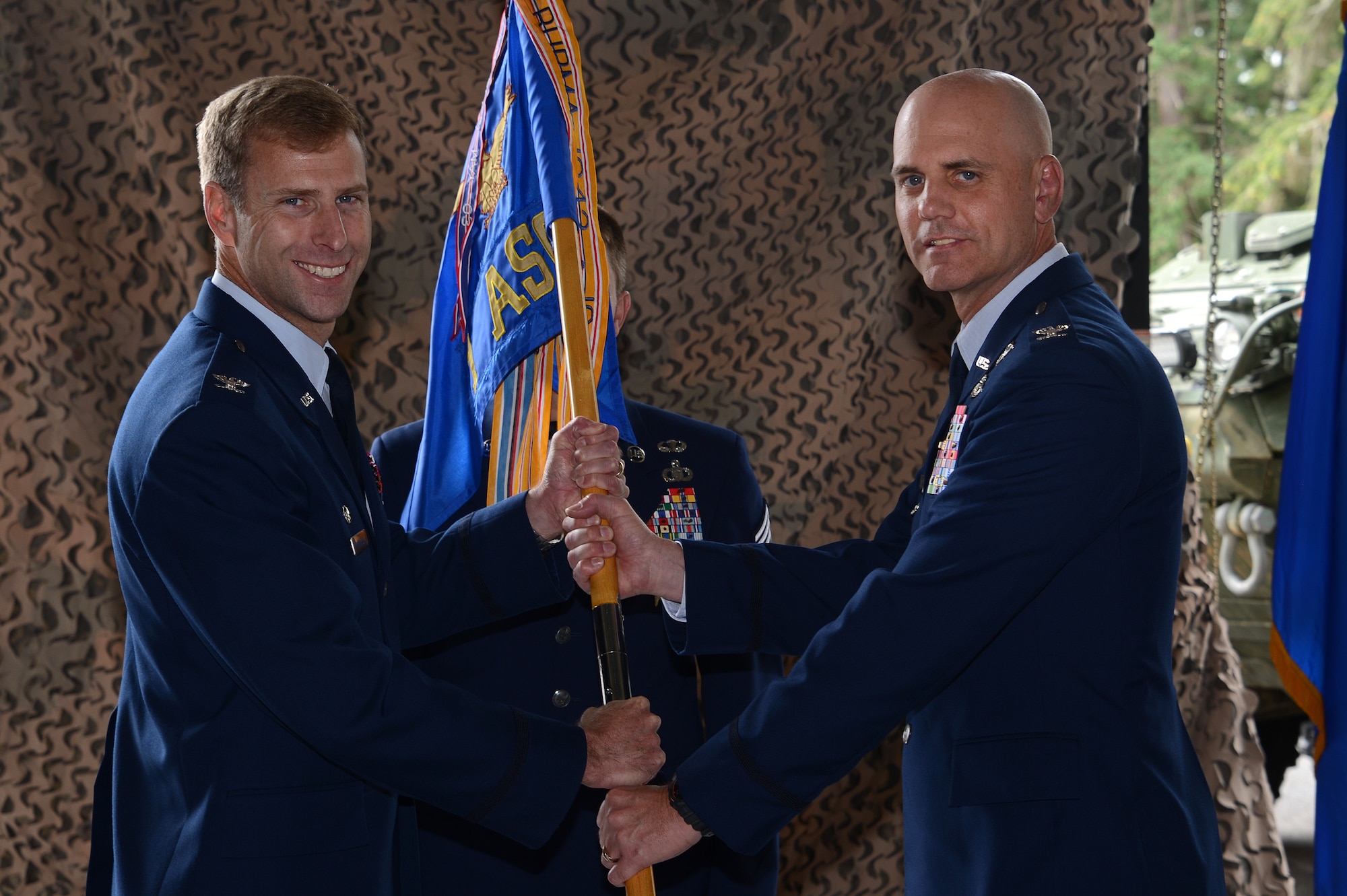 Col. David Mineau (left), 354th Fighter Wing commander, presents the 1st Air Support Operations Group guidon to Col. Jon Berry, 1st ASOG commander during a change of command ceremony July 7, 2016, at Joint Base Lewis-McChord, Wash. Berry assumed command of the group from the outgoing commander Col. James Bowen. (U.S. Air Force photo/Senior Airman Jacob Jimenez) 