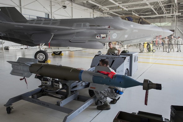 Staff Sgt. Mark Mihacsi, 33rd Aircraft Maintenance Squadron weapons load crew team chief and Senior Airman Danielle Gschwendner, 33rd AMXS weapons load crew member load a GBU-12 on to a jammer during a weapons load competition July 8, 2016, at Eglin Air Force Base, Fla. The load crew competition showcased the efficiency of load crew teams to safely and properly arm an F-35 within time constraints. (U.S. Air Force photo by Senior Airman Stormy Archer/Released)