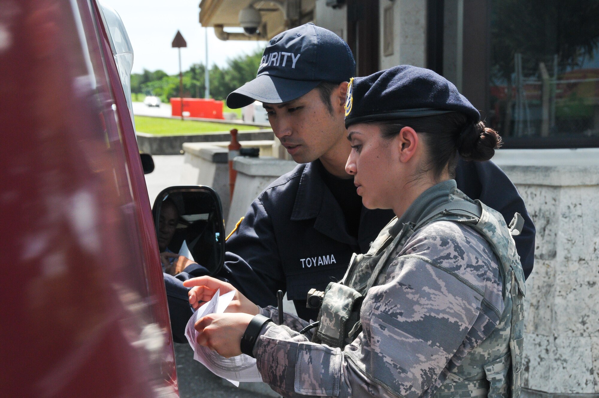 Senior Airman Dominique Castillo (right), 944th Security Forces Squadron member, and Kadena Gate Guard Hiroyuki Toyama, 18th Security Forces Squadron, check a visitor’s credentials in order to allow him base access June 28, 2016, at Gate 1 at Kadena Air Base, Okinawa.  A native Arizonian, Castillo has been a Reservist with the 944th for four years and the opportunity to do an off-station annual tour is valuable to her. The 18th Security Forces Squadron capitalized on the extensive experience 944th SFS members brought during their annual tour by seamlessly integrating them into all of their flights. (U.S. Air Force photo by Staff Sgt. Nestor Cruz)