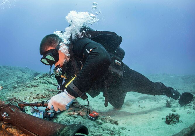 KAUAI, Hawaii (July 6, 2016) - Construction Mechanic 1st Class Matthew Ramirez, with Underwater Construction Team 2 Construction Dive Detachment Bravo (UCT2 CDDB), fastens protective split piping around submerged cables at the Pacific Missile Range Facility Barking Sands. UCT2 CDDB is assigned to the 30th Naval Construction Regiment under Commander, Task Force (CTF) 75, the primary expeditionary task force responsible for the planning and execution of coastal riverine operations, explosive ordnance disposal, diving, engineering and construction, and underwater construction in the U.S. 7th fleet area of responsibility.