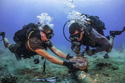 Chief Construction Electrician Daniel Luberto (right) and Construction Mechanic 3rd Class Andersen Gardner, with Underwater Construction Team 2 Construction Dive Detachment Bravo (UCT2 CDDB), remove corroded zinc anodes from an undersea cable at the Pacific Missile Range Facility Barking Sands, Hawaii on July 5, 2016. UCT2 CDDB is assigned to the 30th Naval Construction Regiment under Commander, Task Force (CTF) 75, the primary expeditionary task force responsible for the planning and execution of coastal riverine operations, explosive ordnance disposal, diving, engineering and construction, and underwater construction in the U.S. 7th fleet area of responsibility. 