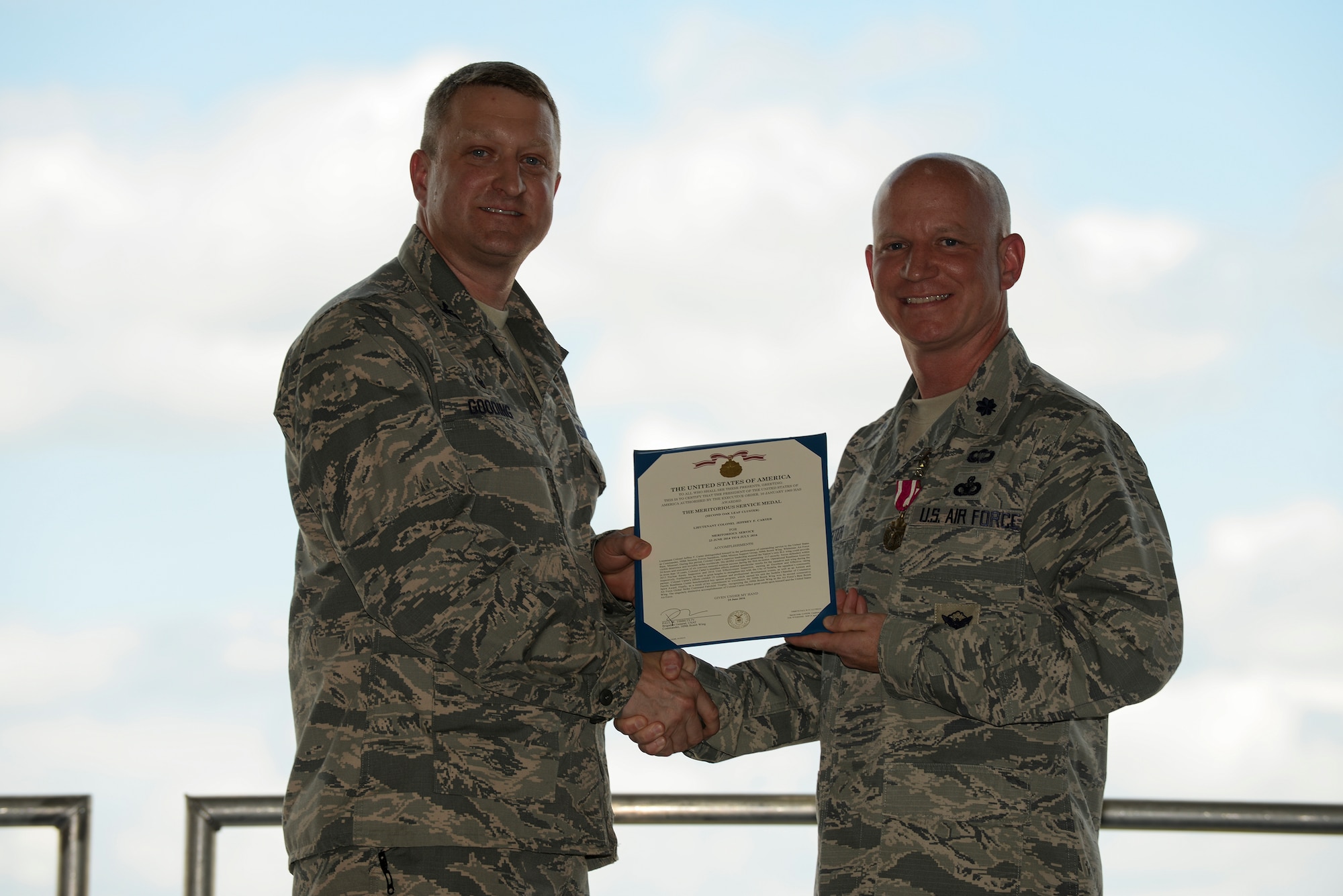 U.S. Air Force Col. Aeneas Gooding, the 509th Mission Support Group commander, presents the Meritorious Service Award to Lt. Col. Jeffery Carter, the outgoing 509th Security Forces Squadron (SFS) commander, at Whiteman Air Force Base, Mo., July 6, 2016. Carter relinquished command of the 509th SFS to Maj. Justin Secrest. (U.S. Air Force photo by Senior Airman Sandra Marrero)