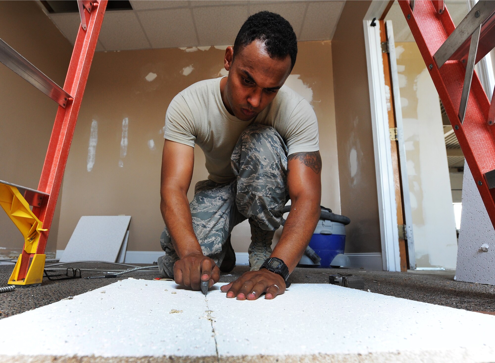U.S. Air Force Staff Sgt. William Shelden, a 509th Civil Engineer Squadron structural journeyman, cuts a new ceiling tile at Whiteman Air Force Base, Mo., July 5, 2016. A building that was previously unoccupied is now being renovated to host the Airman’s Attic. (U.S. Air Force photo by Airman 1st Class Michaela R. Slanchik)