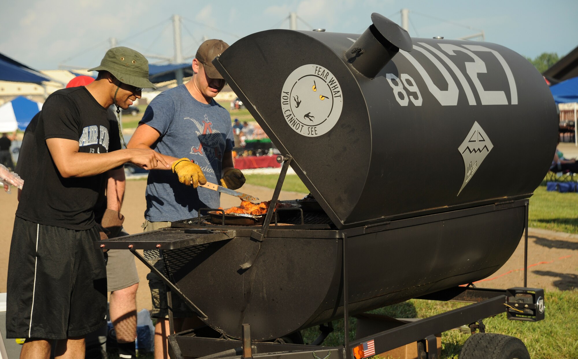U.S. Air Force Senior Airman Christian Anthony, left, and Senior Airman Brandon Orourke, right, 509th Maintenance Squadron members, grill chicken wings during the Independence Day Celebration at Whiteman Air Force Base, Mo., June 30, 2016. Squadrons participated in the event by selling refreshments or supervising activities for Team Whiteman. (U.S. Air Force photo by Senior Airman Danielle Quilla)