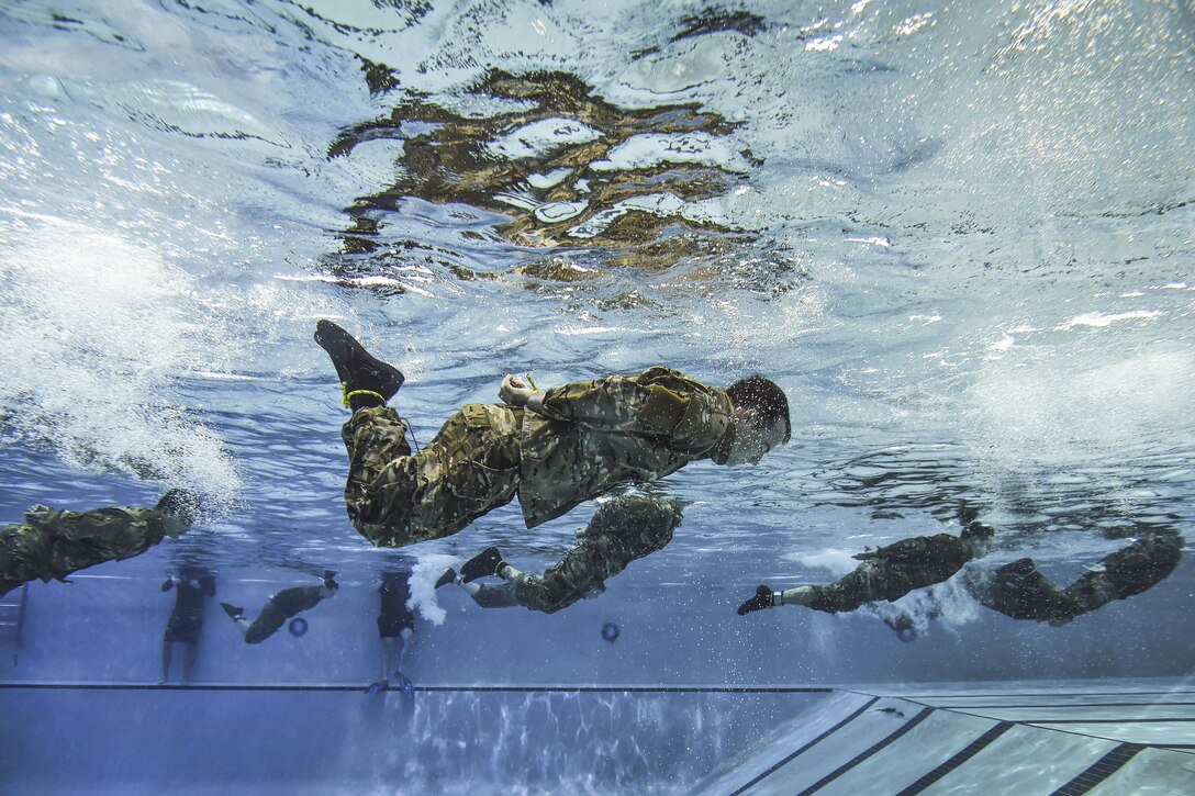 Air Force special tactics students swim the length of the pool with their hands and feet bound during a class before scuba training at Hurlburt Field, Fla., June 29, 2016. The class familiarizes trainees with the basics of water operations. The trainees perform tasks such as tying knots underwater, staying afloat without their arms and hands, and using snorkeling gear. Air Force photo by Senior Airman Ryan Conroy