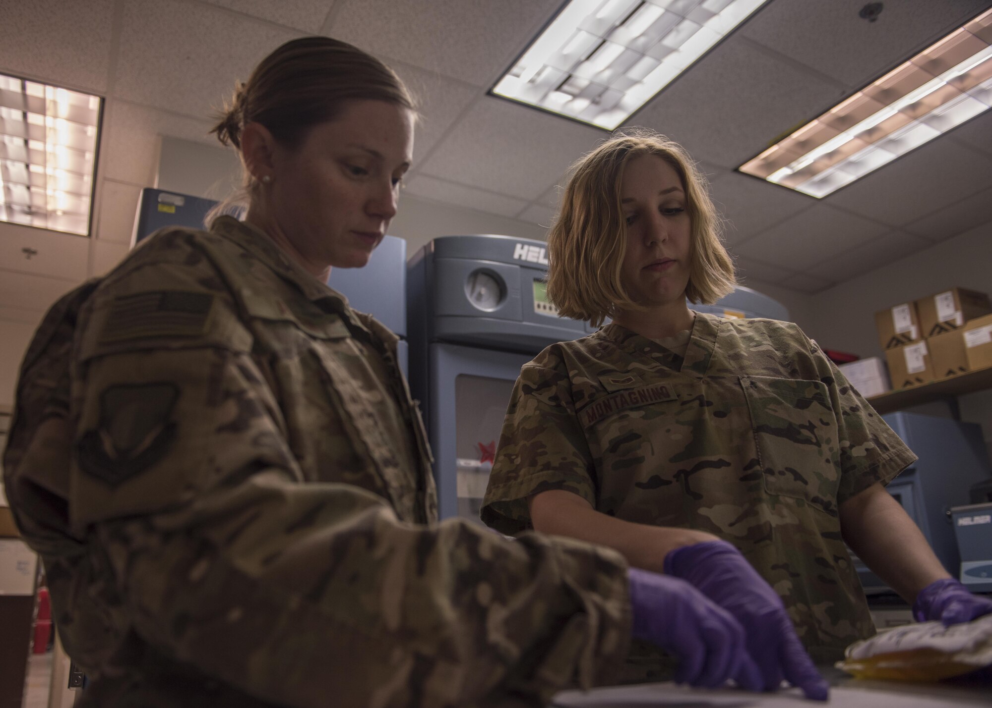 Staff Sgt. Megan Montagnino (right), 455th Expeditionary Medical Group non-commissioned officer in charge of microbiology and the blood bank, verifies details of a blood packet with a technician, July 08, 2016, Bagram Airfield, Afghanistan. Before the blood bank hands out any donation, the blood is tested and systematically checked to ensure patients received the right blood for their needs. (U.S. Air Force photo by Senior Airman Justyn M. Freeman)
