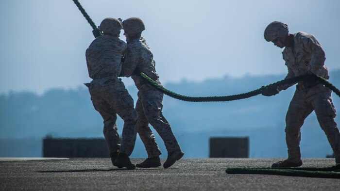Marines with 2nd Battalion, 5th Marine Regiment, Weapons Company, Scout Sniper Platoon, prevent a rope from flailing in the rotor wash of an MV-22B Osprey with Marine Medium Tiltrotor Squadron 164 during fast-rope training aboard Marine Corps Base Camp Pendleton, Calif., June 30. The ability to fast rope enables Marines to insert into an area or structure without landing the aircraft, eliminating the need for a landing zone.