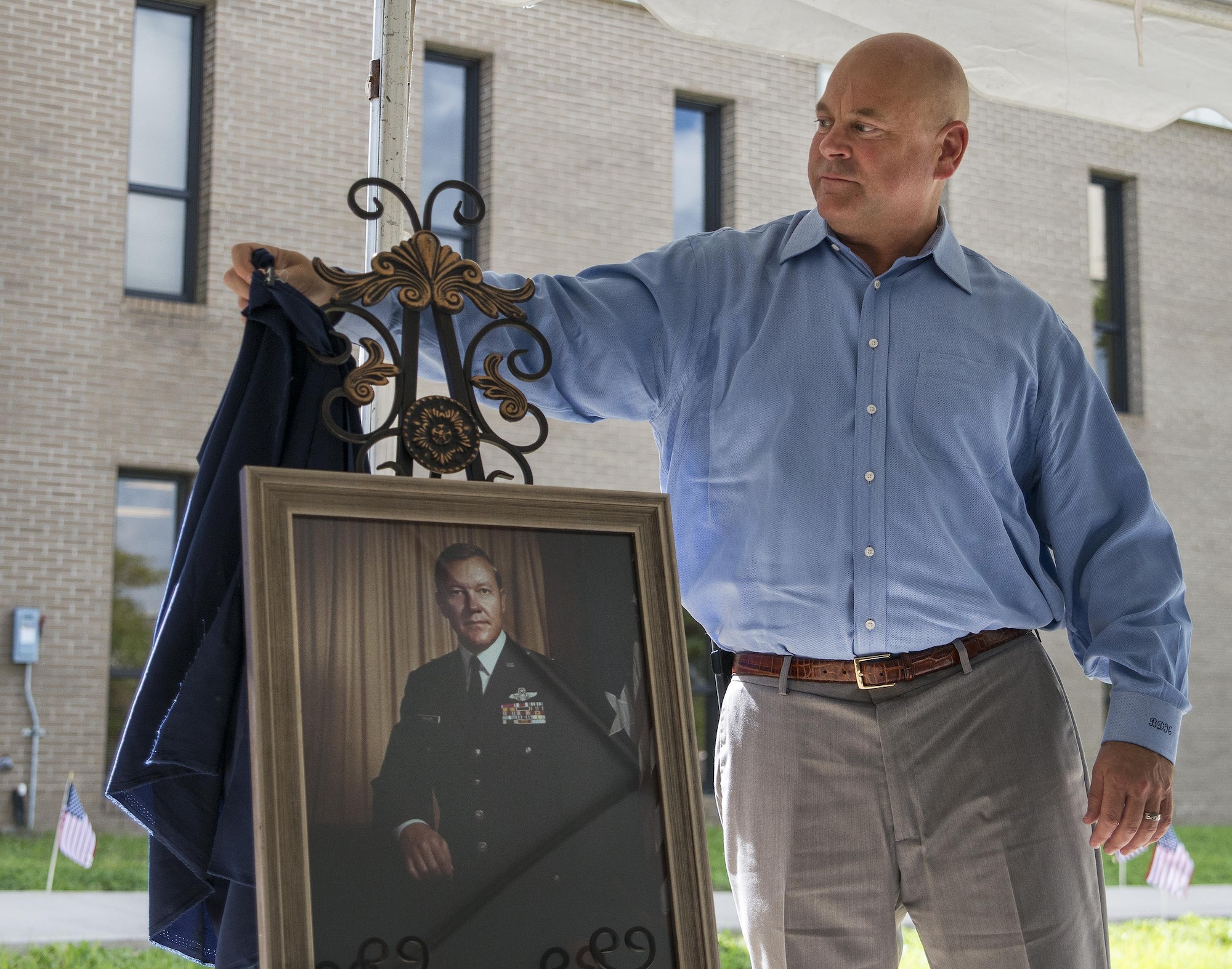 Brian Haugen, the son of retired Brig. Gen. Donald Haugen, unveils the portrait of his father at the 919th Special Operations Wing headquarters building dedication ceremony at Duke Field, Fla., July 8.  The building was dedicated to the 919th’s founding member, Haugen, who created the 919th Tactical Airlift Group in 1971.  The portrait will be hung in the newly-named Haugen Headquarters.  (U.S. Air Force photo/Tech. Sgt. Sam King)