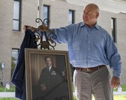 Brian Haugen, the son of retired Brig. Gen. Donald Haugen, unveils the portrait of his father at the 919th Special Operations Wing headquarters building dedication ceremony at Duke Field, Fla., July 8.  The building was dedicated to the 919th’s founding member, Haugen, who created the 919th Tactical Airlift Group in 1971.  The portrait will be hung in the newly-named Haugen Headquarters.  (U.S. Air Force photo/Tech. Sgt. Sam King)