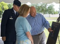 Brain and Diana, son and daughter of retired Brig. Gen. Donald Haugen, examine the bronze plaque of their father with Col. James Phillips, the 919th Special Operations Wing commander, after a building dedication ceremony at Duke Field, Fla., July 8.  The building was dedicated to the 919th’s founding member, Haugen, who created the 919th Tactical Airlift Group in 1971.  (U.S. Air Force photo/Tech. Sgt. Sam King)