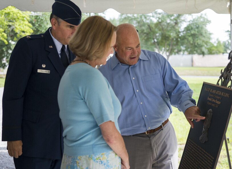 Brain and Diana, son and daughter of retired Brig. Gen. Donald Haugen, examine the bronze plaque of their father with Col. James Phillips, the 919th Special Operations Wing commander, after a building dedication ceremony at Duke Field, Fla., July 8.  The building was dedicated to the 919th’s founding member, Haugen, who created the 919th Tactical Airlift Group in 1971.  (U.S. Air Force photo/Tech. Sgt. Sam King)
