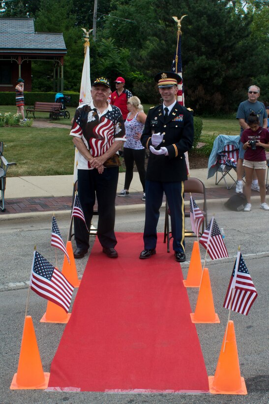 John Curin, left, a Korean War Combat Veteran and Grand Marshall of the Brookfield, Illinois Independence Day parade, and Cpt. Zachary Galaboff, commander of Headquarters and Headquarters Company (HHC) 416th Theater Engineer Command, applaud as participants of the parade travel past the grandstand, Jul. 4, 2016. (U.S. Army photo by Staff Sgt. Jason Proseus/Released)