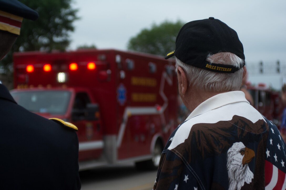 John Curin, a Korean War Combat Veteran and Grand Marshall of the Brookfield, Illinois Independence Day parade, watches and applauds as participants of the parade travel past the grandstand, Jul. 4, 2016. (U.S. Army photo by Staff Sgt. Jason Proseus/Released)