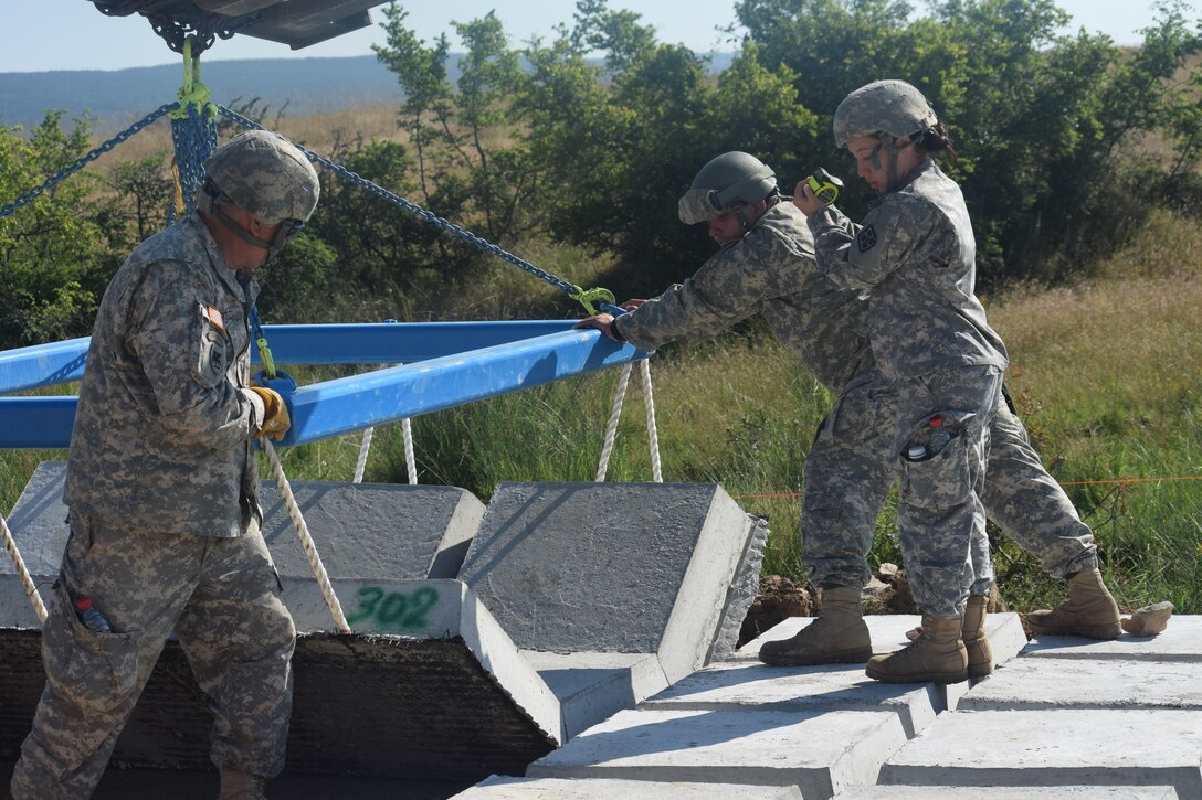 Sergeant Grace De Los Reyes, Sergeant Nic Ortiz, Specialist Ryne Chavez, Specialist Jovany Tavera and Specialist Luis Ballester, engineers with the 841st Engineer Battalion, U.S. Army Reserve install concrete to strengthen vulnerable areas of road on July 3rd, 2016 during Operation Resolute Castle at Novo Selo Training Area, Bulgaria. (U.S. Army photo by Capt. Kimberlee Lewis, 841st Engineer Battalion, United States Army Reserve)