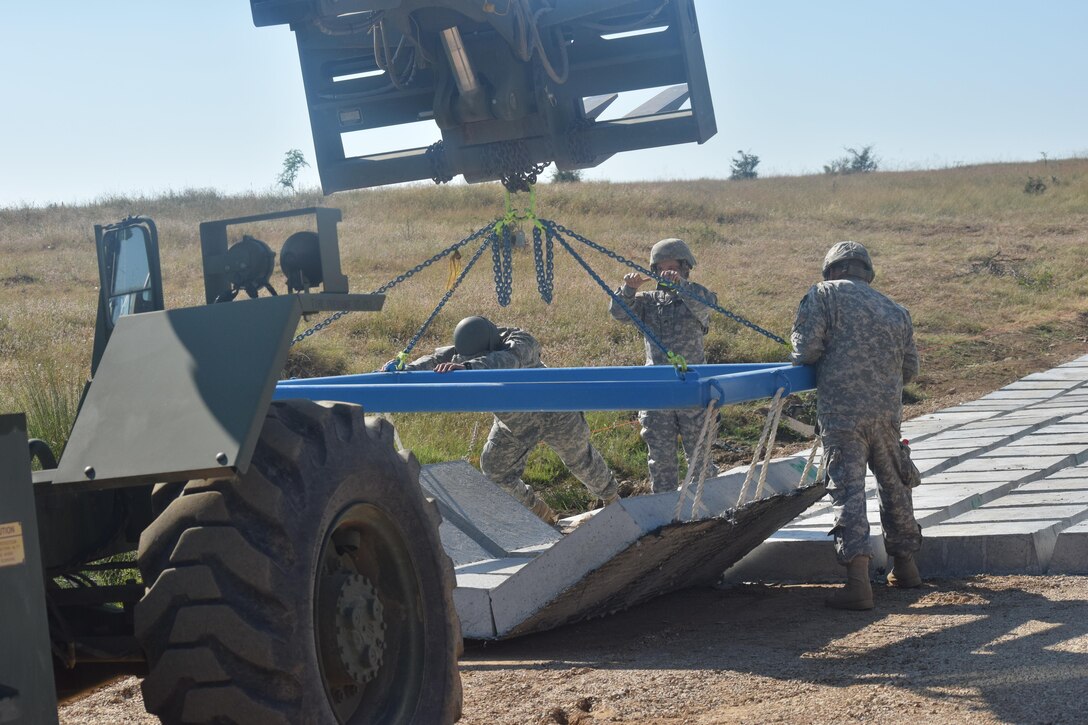 Sergeant Grace De Los Reyes, Sergeant Nic Ortiz, Specialist Ryne Chavez, Specialist Jovany Tavera and Specialist Luis Ballester, engineers with the 841st Engineer Battalion, U.S. Army Reserve install concrete to strengthen vulnerable areas of road on July 3rd, 2016 during Operation Resolute Castle at Novo Selo Training Area, Bulgaria. (U.S. Army photo by Capt. Kimberlee Lewis, 841st Engineer Battalion, United States Army Reserve)