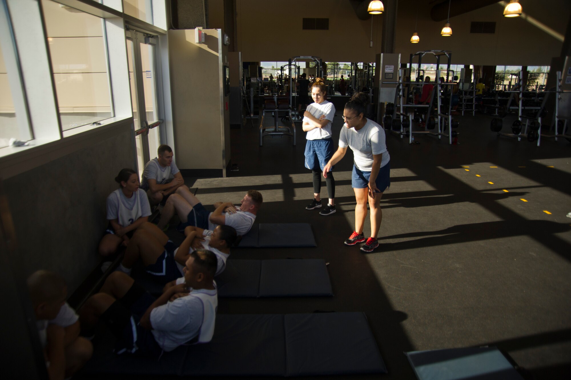 Staff Sgt. Deanna Sanchez, 926th Force Support Squadron Fitness Assessment Cell NCOIC, corrects the form of 926th Wing members performing the sit-ups portion of their physical fitness test July 9, 2016 at the Warrior Fitness Center. The 926th FSS supports the fitness testing of 926th Wing members and provides specialized culinary training for  new services Airmen whose career focus is food services.