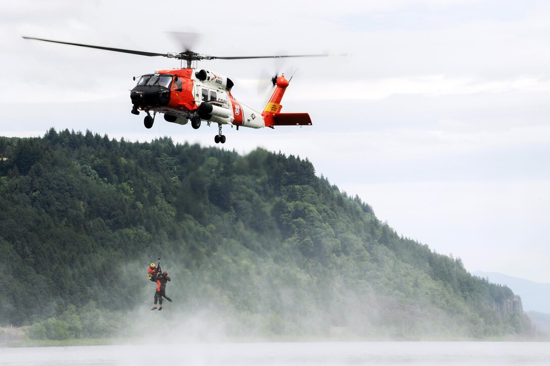 The crew of a Coast Guard MH-60 Jayhawk lifts a pilot from the Columbia River during a water survival exercise in Corbett, Ore., July 7, 2016. Air National Guard photo by Tech. Sgt. John Hughel
