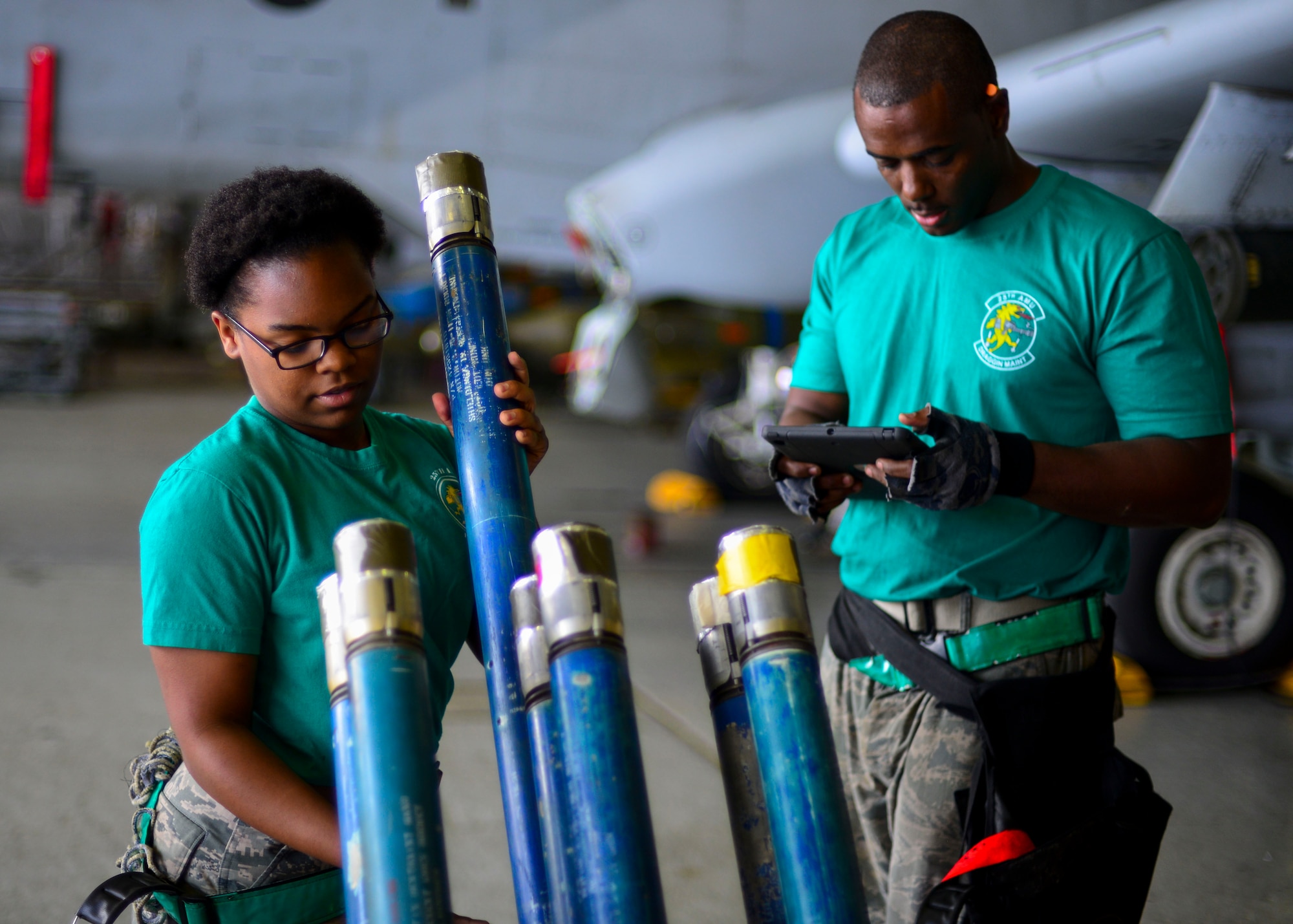Airman 1st Class Saravia Boykins, 25th Aircraft Maintenance Unit weapons load crew member, prepares to load a strafe-run rocket on an A-10 Thunderbolt II while Staff Sgt. Michael Johnson, 25th AMU weapons load crew team chief, reads over their technical orders to ensure proper protocol is followed during the 51st Maintenance Group Weapons Load Crew of the Quarter competition at Osan Air Base, Republic of Korea, July 7, 2016. The best weapons load crews from the 36th and 25th AMUs competed to see who could arm their aircraft the quickest and with the most precision. (U.S. Air Force photo by Senior Airman Victor J. Caputo/Released)