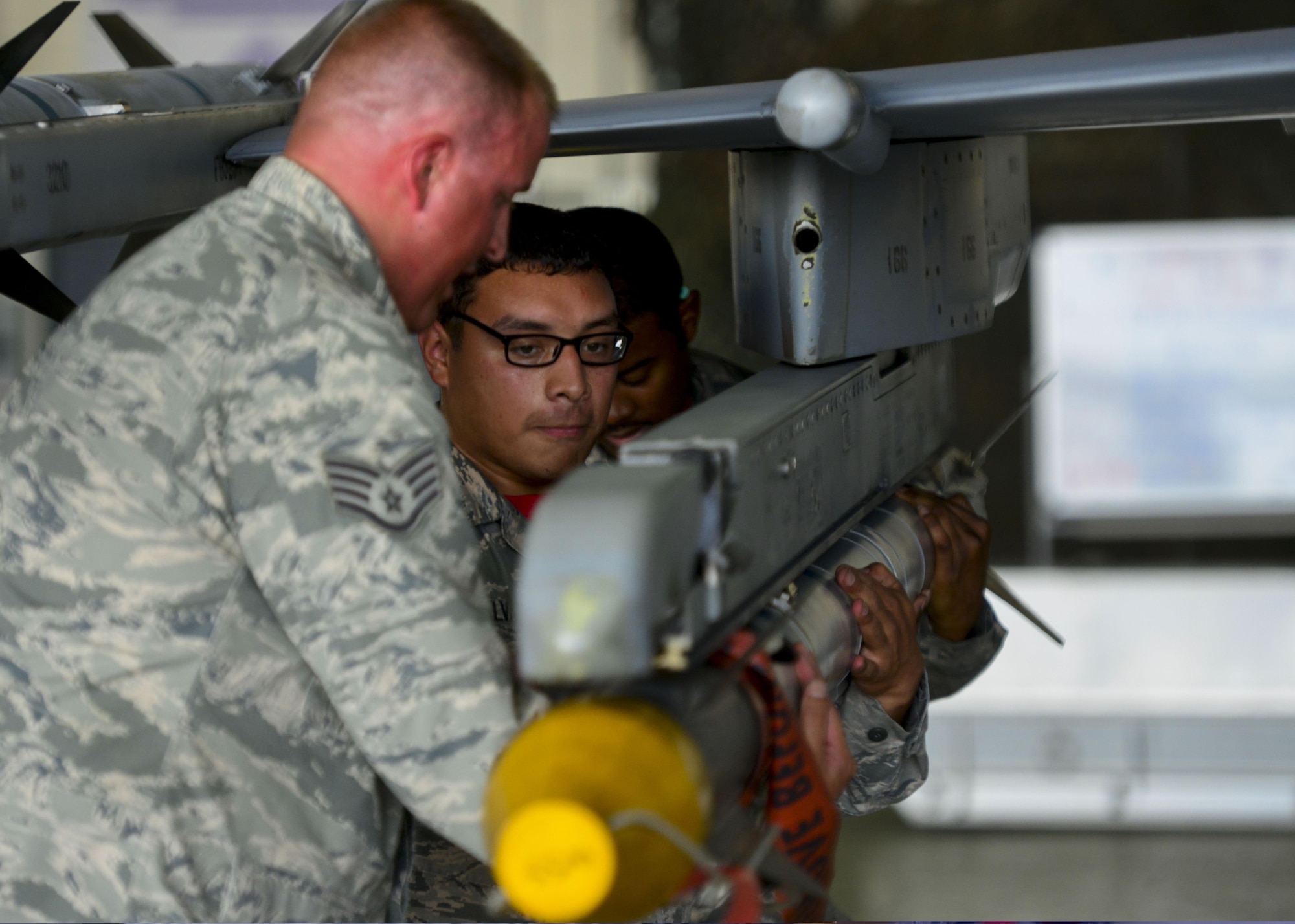 The 36th Aircraft Maintenance Unit weapons load crew team fastens an AIM-9 Sidewinder missile to an F-16 Fighting Falcon during the 51st Maintenance Group Weapons Load Crew of the Quarter competition at Osan Air Base, Republic of Korea, July 7, 2016. Weapons load teams from the 25th and 36th AMUs competed in dress and appearance, timing and technical order proficiency during the event. (U.S. Air Force photo by Senior Airman Victor J. Caputo/Released)