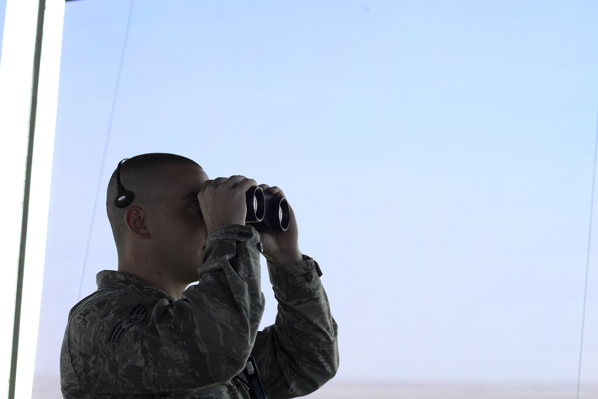 U.S. Air Force Senior Airman Ryan Colomo, 379th Expeditionary Operations Support Squadron Air Traffic Control journeyman, observes the runway at Al Udeid Air Base, Qatar, June 13, 2016. Colomo, a native of Mechanicsville, Md., keeps in contact with the local airport throughout the day as a means of tracking aircraft. (U.S. Air Force photo by Senior Airman Kimberly Nagle) 