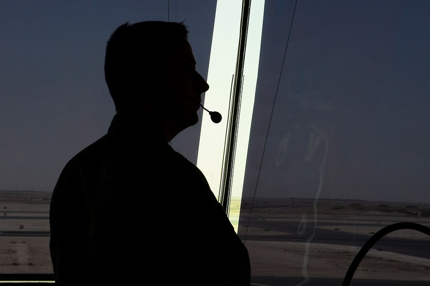 U.S. Air Force Tech. Sgt. Dallas Bloss, 379th Expeditionary Operations Support Squadron, NCO in charge of training and standardization, keeps watch of the runway as aircraft land and depart at Al Udeid Air Base, Qatar, June 13, 2016. Dallas, a native of Gas City, Ind., tracks air and ground movements by listening to incoming and outgoing transmissions from the facility, pilots and vehicles. (U.S. Air Force photo by Senior Airman Kimberly Nagle) 