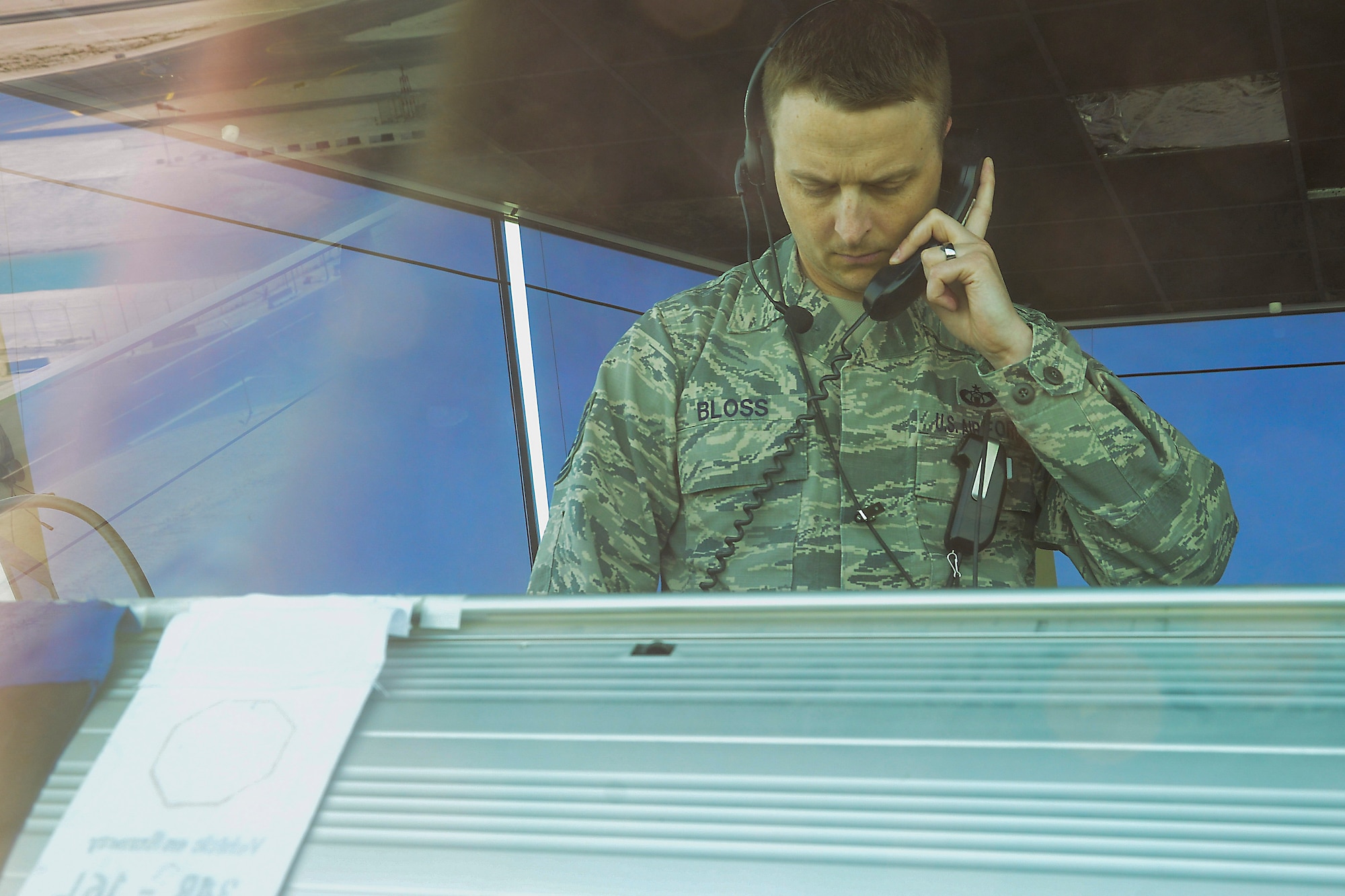 U.S. Air Force Tech. Sgt. Dallas Bloss, 379th Expeditionary Operations Support Squadron, NCO in charge of training and standardization, speaks with an individual that contacted the tower for further directions at Al Udeid Air Base, Qatar, June 13, 2016. In addition to monitoring USAF Air Traffic Control members, Dallas, a native of Gas City Ind., supports the coalition forces that share the tower. (U.S. Air Force photo by Senior Airman Kimberly Nagle)  