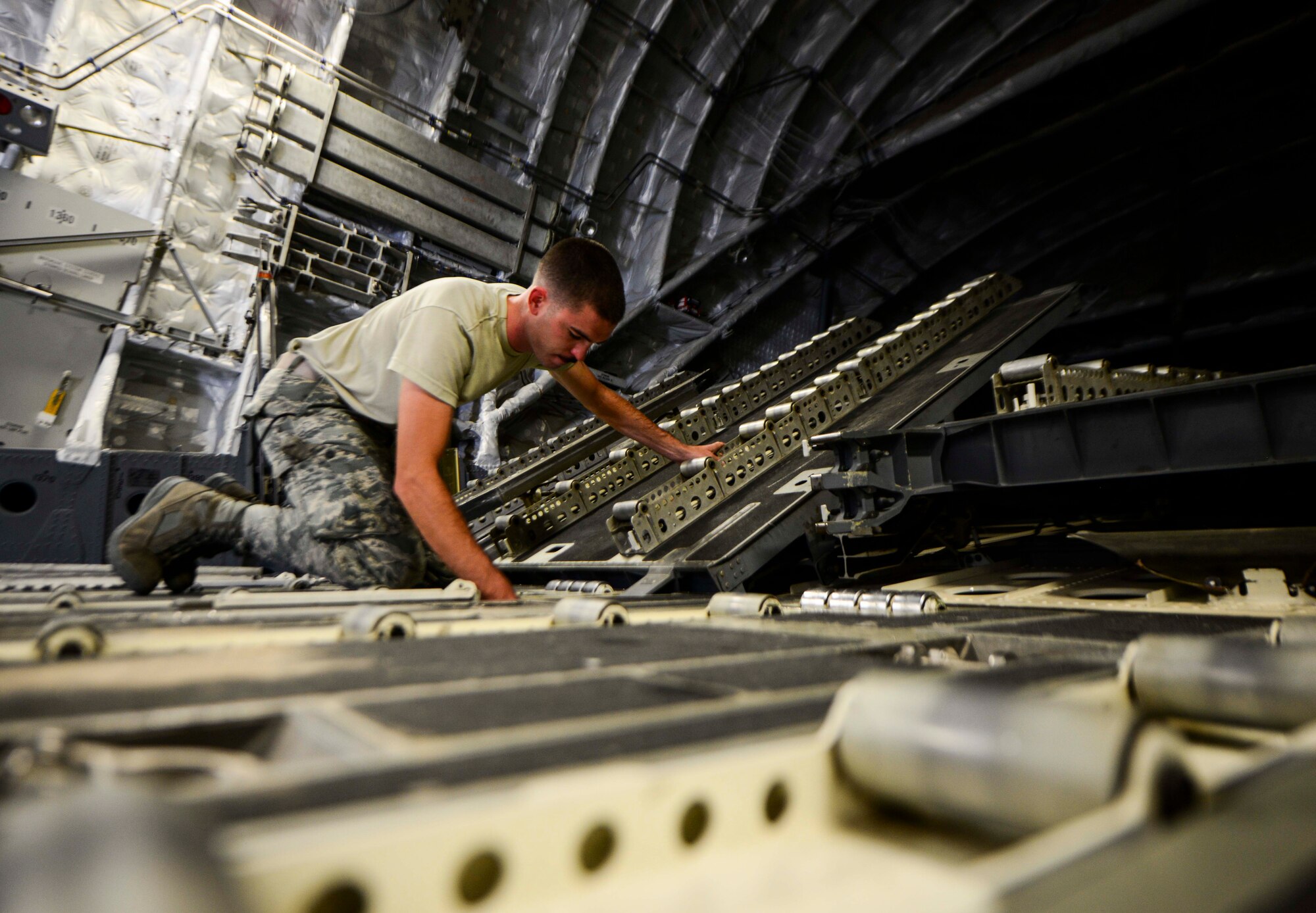 Staff Sgt. Josh Budinich, 8th Expeditionary Air Mobility Squadron, Aircraft Maintenance Flight aero repair craftsman, installs the C-17 Globemaster III cargo ramp toes during a preflight inspection June 30, 2016, at Al Udeid Air Base, Qatar. Depending on the situation of the aircraft, inspections can take nearly three hours to ensure the aircraft is prepared for the next mission.  One of the many challenges Airmen face here is the impact of heat on various systems; with the warm weather, Airmen have to keep the aircraft at a constant temperature while operating on any of the systems to prevent additional issues. (U.S. Air Force photo/Senior Airman Janelle Patiño/Released)