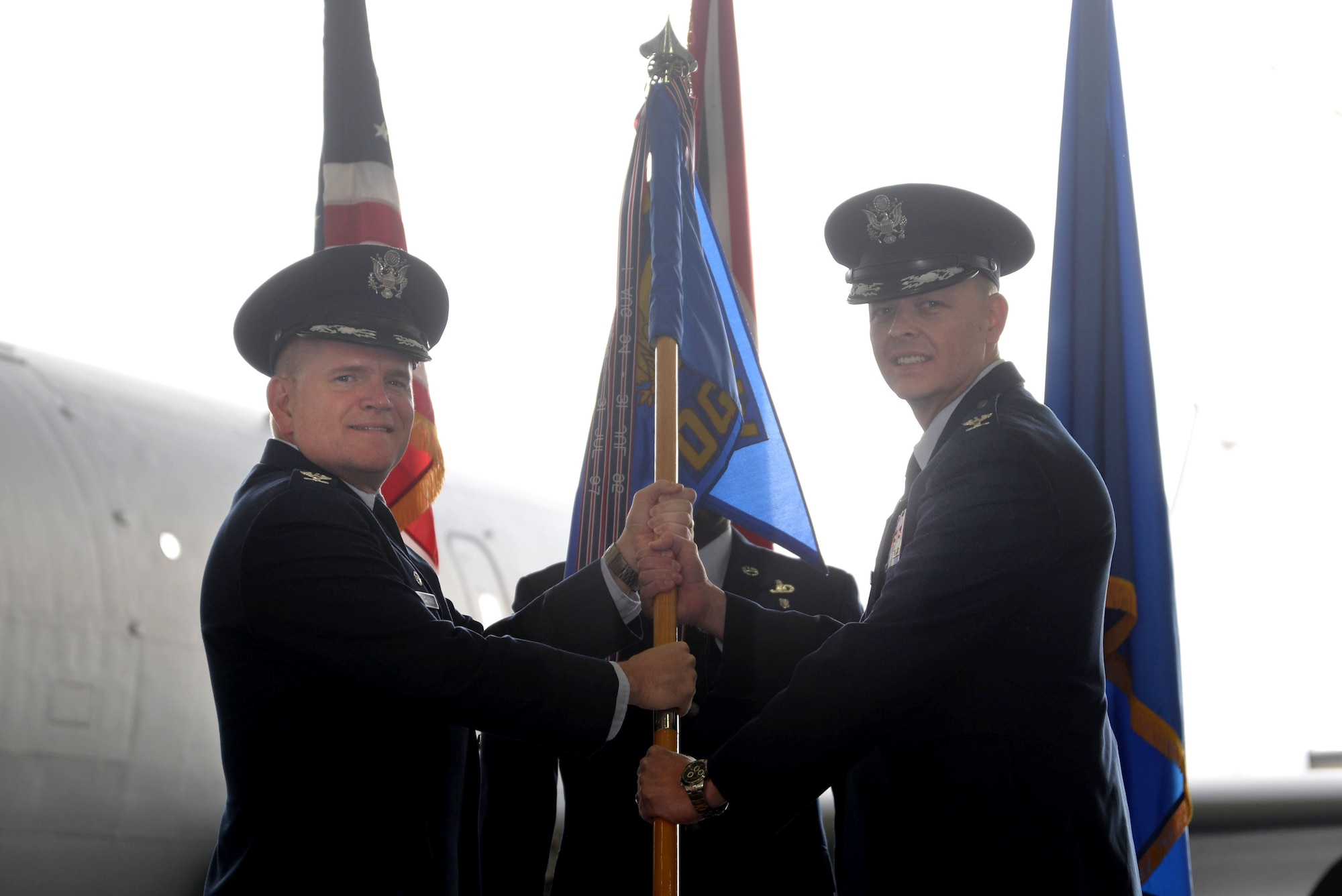 U.S. Air Force Col. Thomas Torkelson, left, 100th Air Refueling Wing commander, passes the 100th Operations Group guidon to U.S. Air Force Col. Derek Salmi, incoming 100th OG commander, during a change of command ceremony June 28, 2016, on RAF Mildenhall, England. The 100th OG is responsible for the planning, scheduling and execution of all U.S. Air Forces in Europe air refueling operations, and accountable for mission readiness, mobilization, employment, training and standardization of 15 KC-135R Stratotanker aircraft and 245 permanently assigned aircrew and support personnel. (U.S. Air Force photo by Staff Sgt. Kate Thornton/Released)