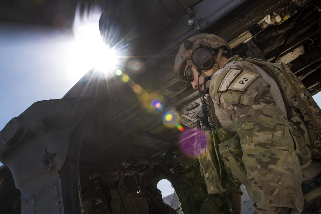 Air Force Staff Sgt. Roderick Campbell boards an HH-60G Pave Hawk helicopter before participating in a personnel recovery exercise at Bagram Airfield, Afghanistan, July 9, 2016. Campbell is a pararescueman assigned to the 83rd Expeditionary Rescue Squadron. Air Force photo by Senior Airman Justyn M. Freeman