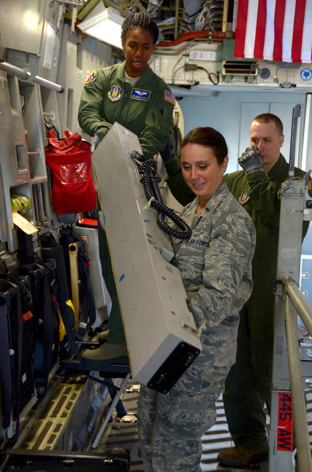 Senior Airman Aaliyah R. Lovett, an aeromedical evacuation technician from the 445th Aeromedical Evacuation Squadron, hands an electrical and lighting piece of a litter stanchion system to 1st Lt. Jeannie M. Kibert, a flight nurse from the 445th AES, as Master Sgt. Sean R. Smith, NCO in charge of aircrew training for the 445th AES, observes June 6, 2016, on a C-17 Globemaster III cargo aircraft at Wright-Patterson Air Force Base. Smith observes the Airmen to ensure safety and proper procedures. (U.S. Air Force Photo by Senior Airmen Joel A. McCullough)