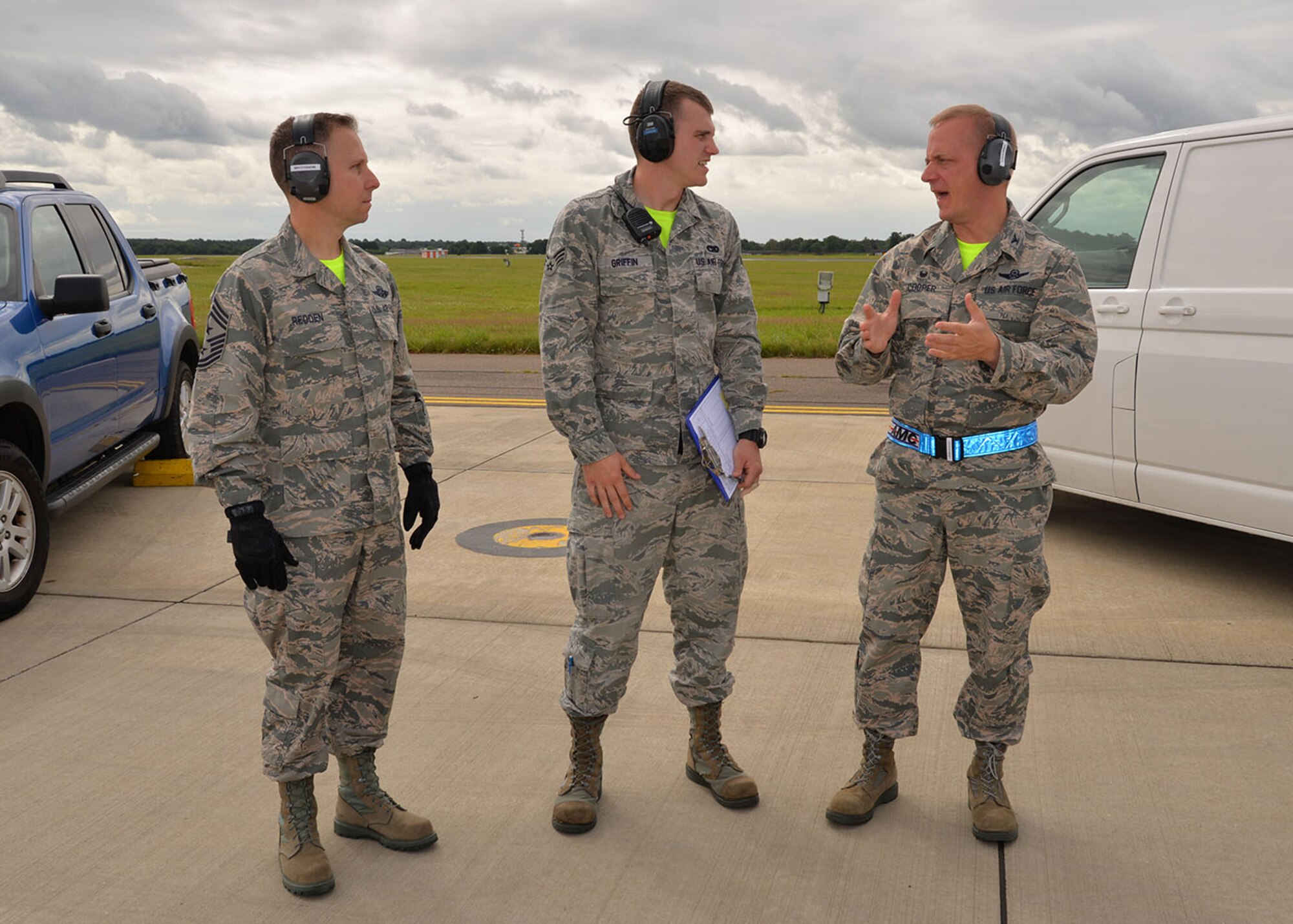 U.S. Air Force Col. Thomas Cooper, right, 521st Air Mobility Operations Wing commander, asks questions to U.S. Air Force Senior Airman Sylvester Griffin, 727th Air Mobility Squadron Air Terminal Operations Center information controller, about the procedures for checking aircraft July 1, 2016, on RAF Mildenhall, England. Cooper recently took command of the 521st AMOW and visited the 727th AMS, along with Chief Master Sgt. Mark Redden, left, 521st AMOW command chief, to meet Airmen and Ministry of Defence civilians under his command. (U.S. Air Force photo by Karen Abeyasekere/Released)