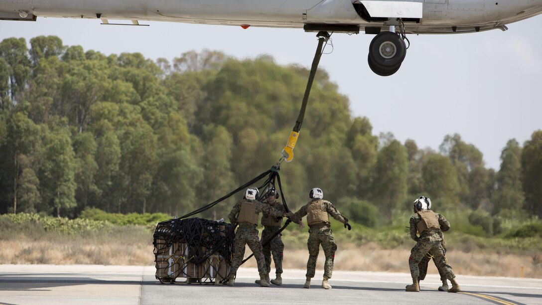 Landing support specialists with Combat Logistics Battalion 2, Special Purpose Marine Air-Ground Task Force-Crisis Response-Africa, attach a 1,098 pound pallet of Meals, Ready to Eat to an MV-22B Osprey during a helicopter support team exercise at Naval Station Rota, Spain, July 6, 2016. This training prepares Marines to deliver and recover supplies and equipment quickly and efficiently in potential future missions around Europe and Africa.